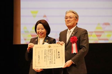 President Ikemi (right) receives a certificate of commendation from Hanako Jimi (left), Minister of State for Special Missions, Cabinet Office, Government of Japan